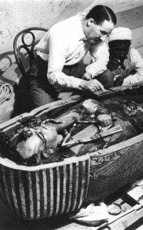 Говард Картер, английский археолог, рассматривает открытый саркофаг Тутанхамона